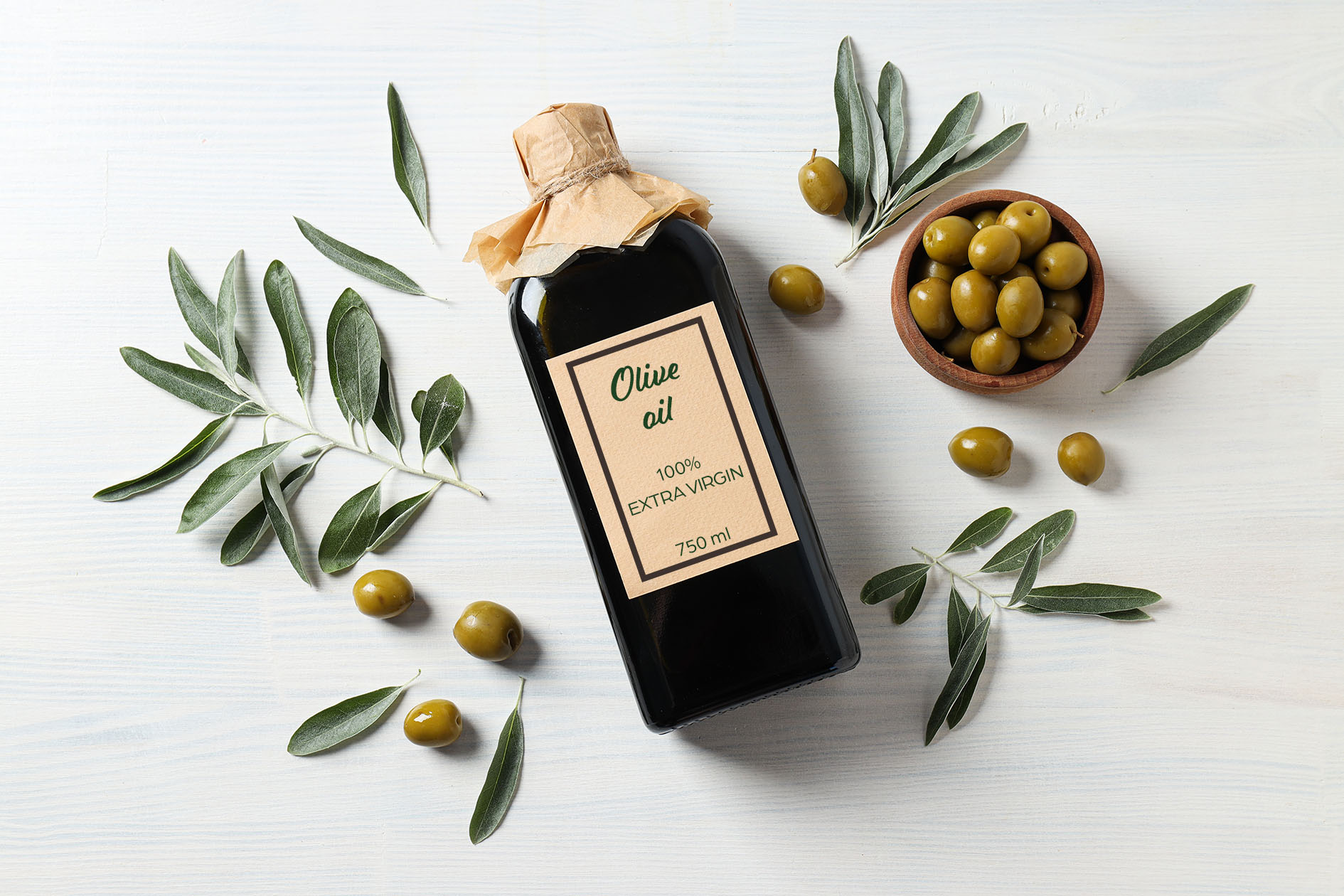 Olive oil bottle and olives on white wooden background, top view